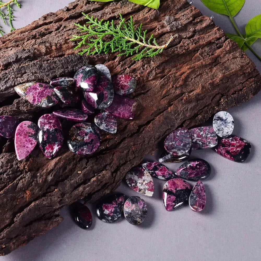 Purple gemstones on a wooden surface with green leaves