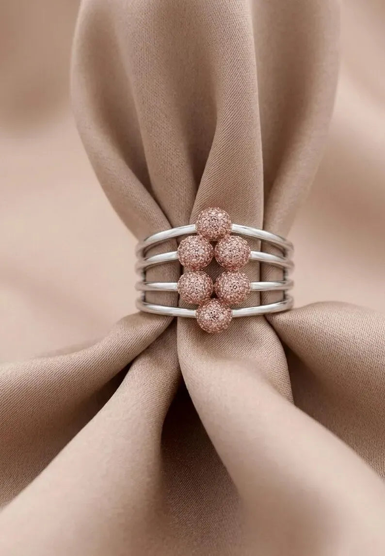 Chunky rings, angled view of a 925 sterling silver ring for women with four parallel bands and rose gold CZ beads