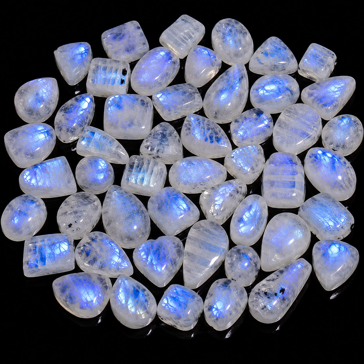 Collection of teardrop-shaped stones with blue fluorescence on a black background