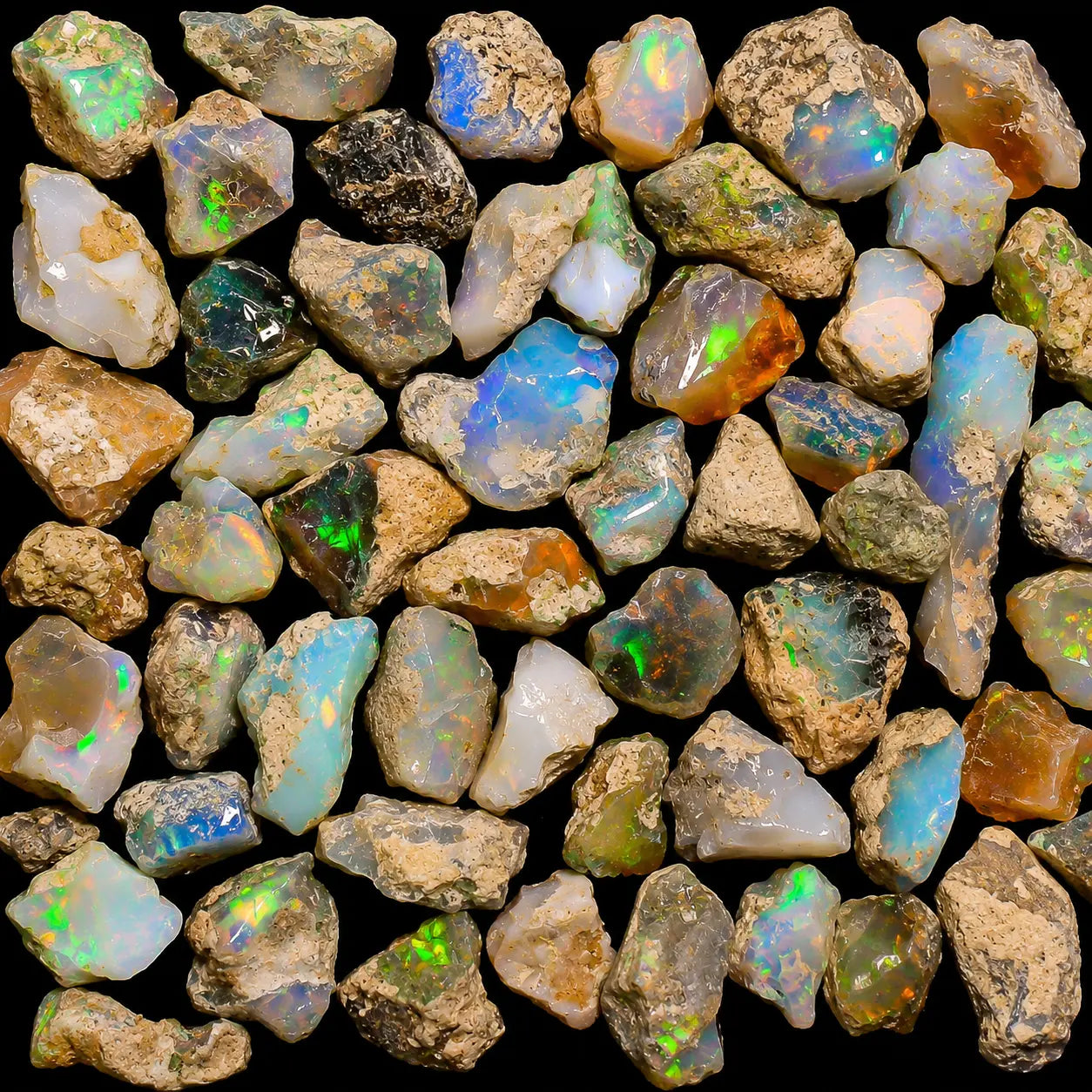 Collection of raw opal stones with various colors on a black background