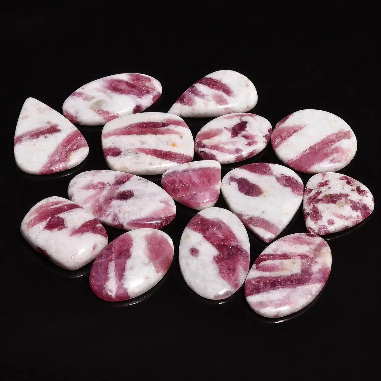 Collection of pink and white marbled stones on a black background