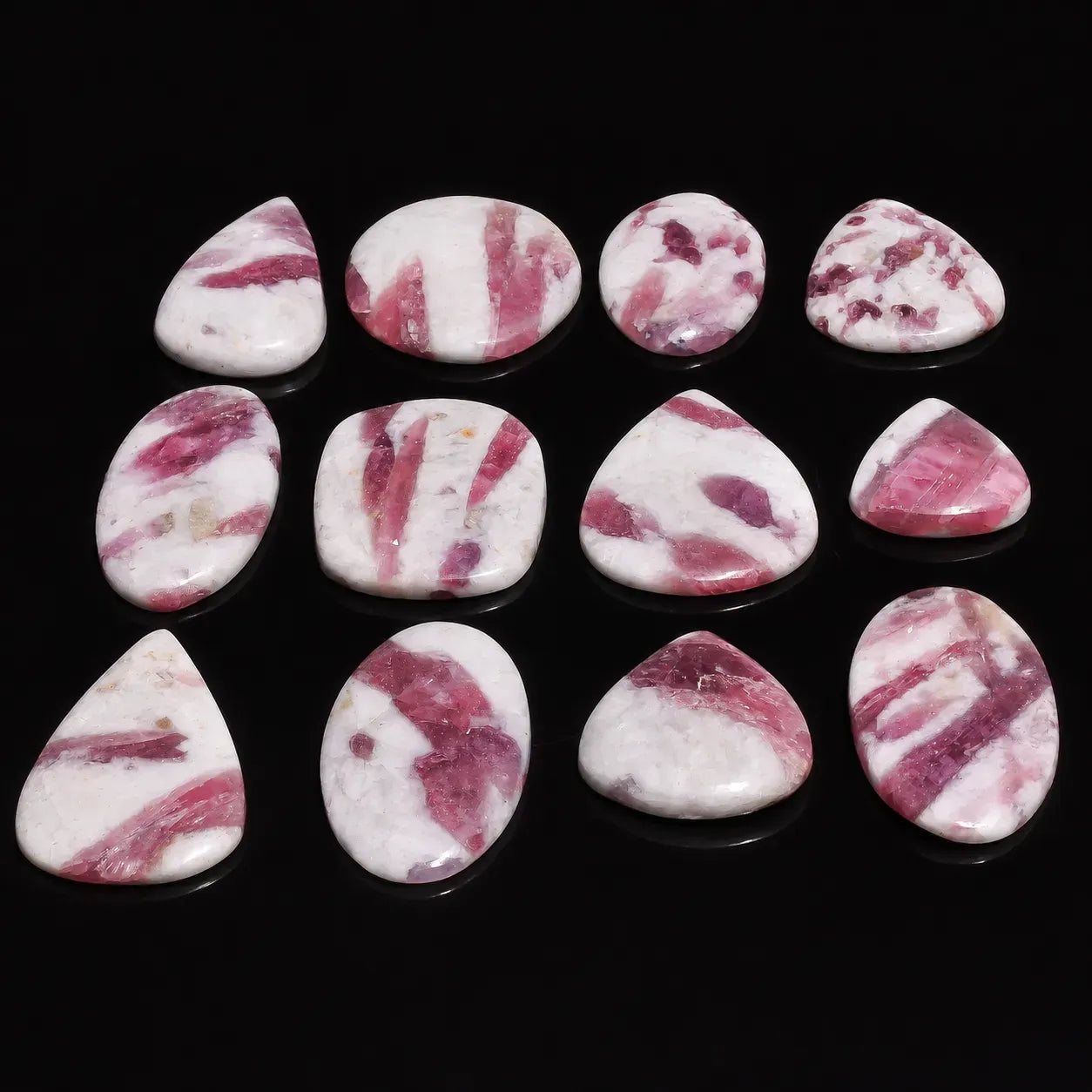 Set of pink and white marbled stones on a black background