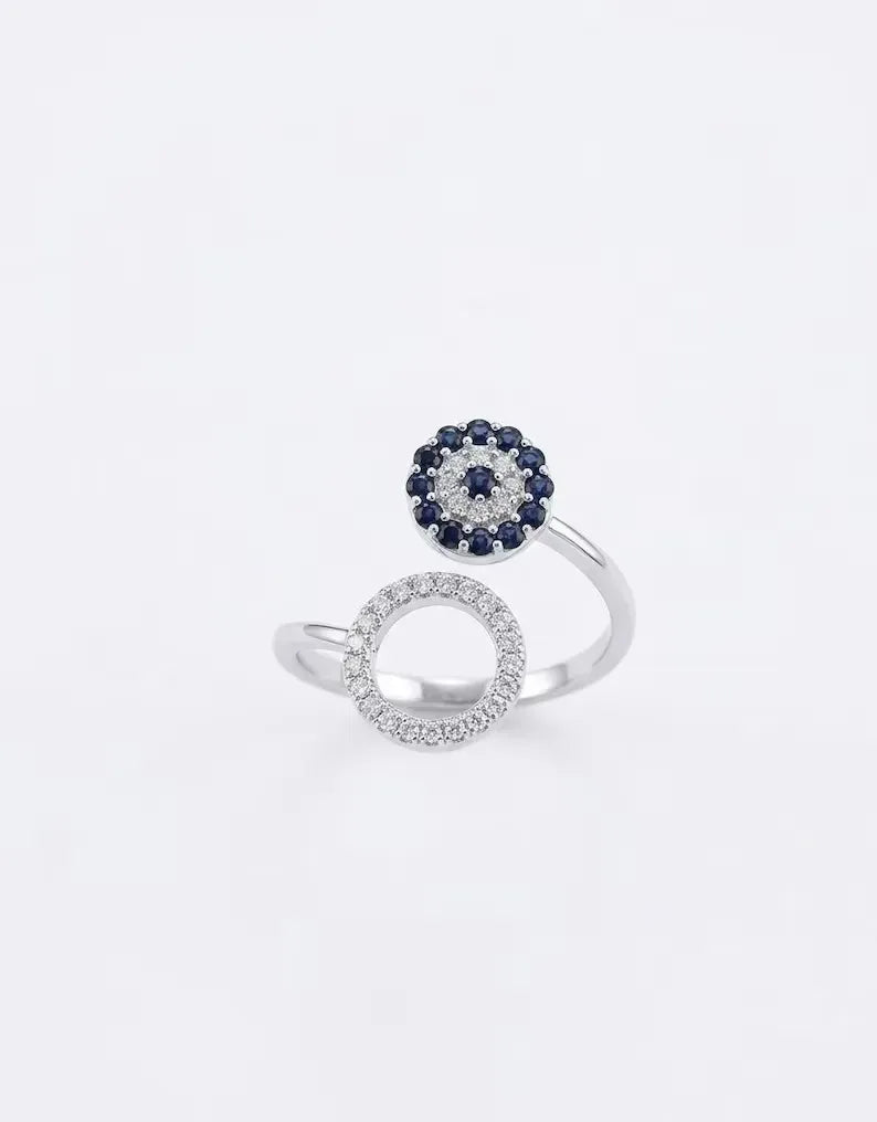 Close up of sterling silver open ring with blue evil eye motif and pave circle design