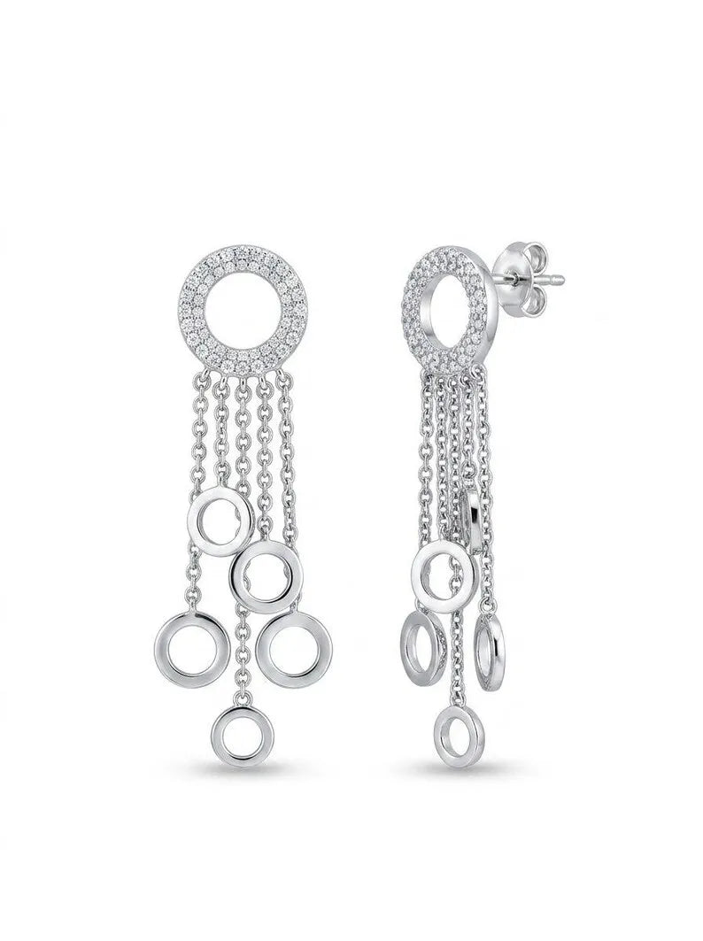 A pair of silver dangle earrings with circular cutouts, pavé-set stones at the top, and hanging chain details, shown on a plain white background.