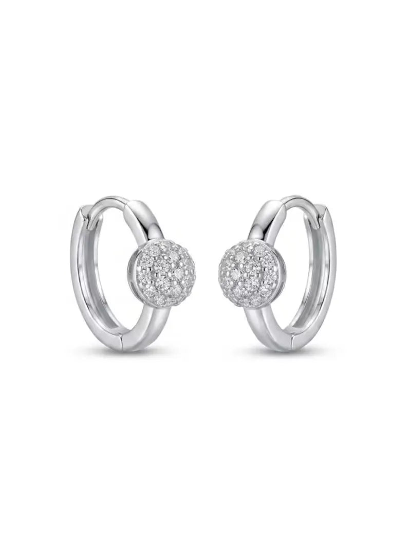A pair of silver huggie hoop earrings with a central pavé-set round diamond, shown on a clean white background.