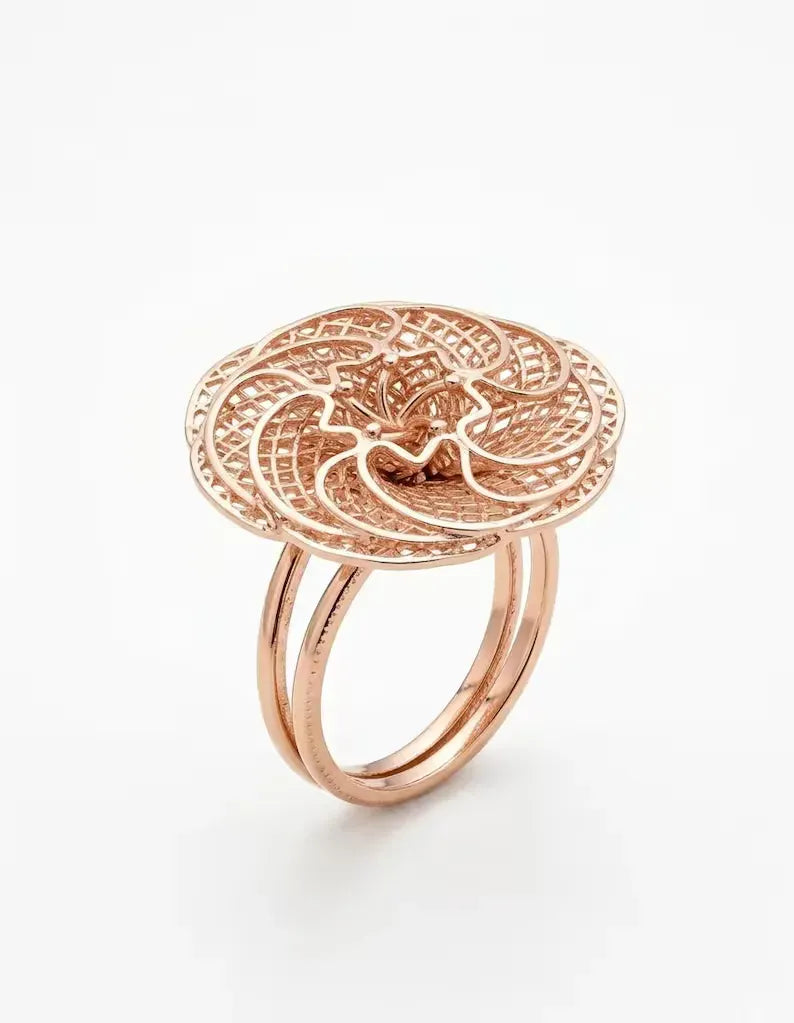 Side angle view of rose gold sterling silver floral filigree ring with double band shank