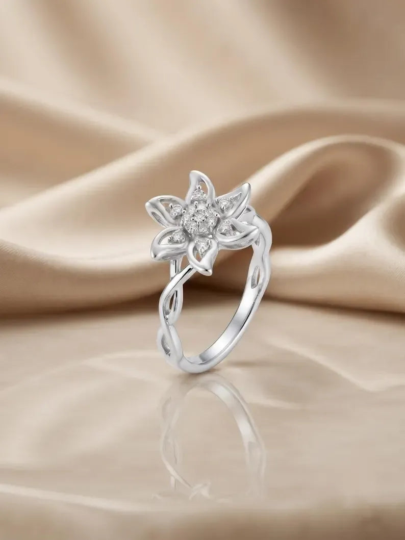 Close up of hand wearing floral sterling silver ring with twisted vine band