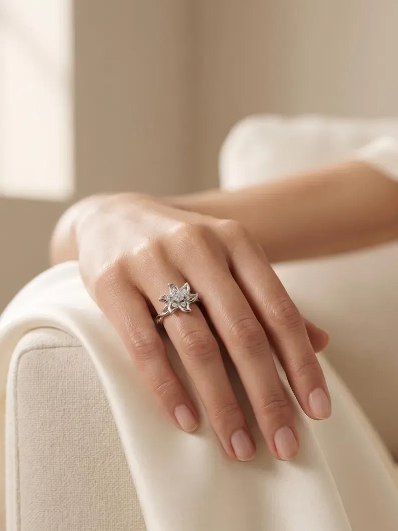 Close up of sterling silver floral CZ ring on satin fabric background