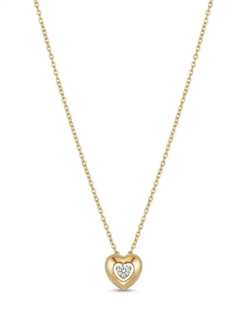 A delicate gold chain necklace featuring a small heart-shaped pendant with a textured gold border and a smaller central heart paved with clear stones, shown against a plain white background.
