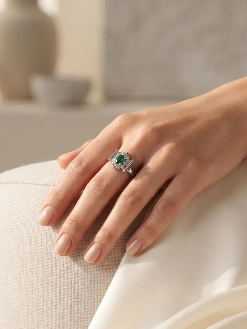 Hand resting on cream armchair wearing green gemstone sterling silver ring