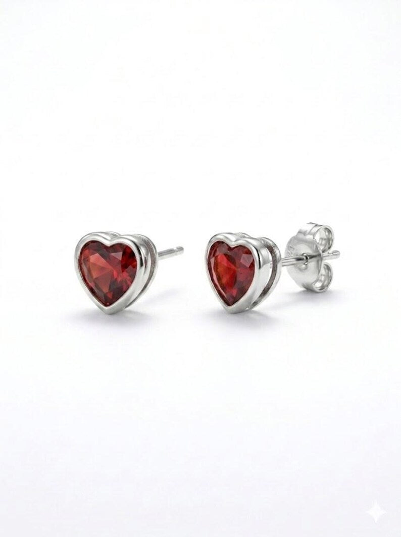 Pair of garnet-red heart stud earrings, bezel set