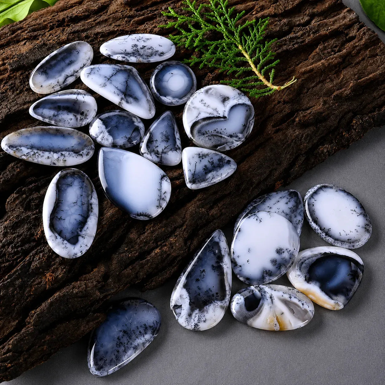 Marble-like stones on a wooden surface with a green leaf