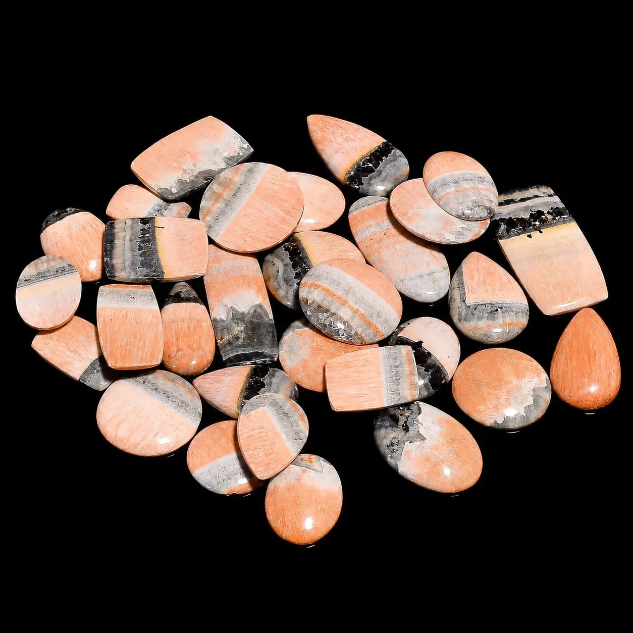Collection of pink and gray striped stones on a black background