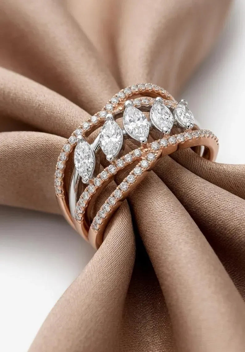Side angle view of sterling silver rose gold cocktail ring with graduated marquise cut CZ stones