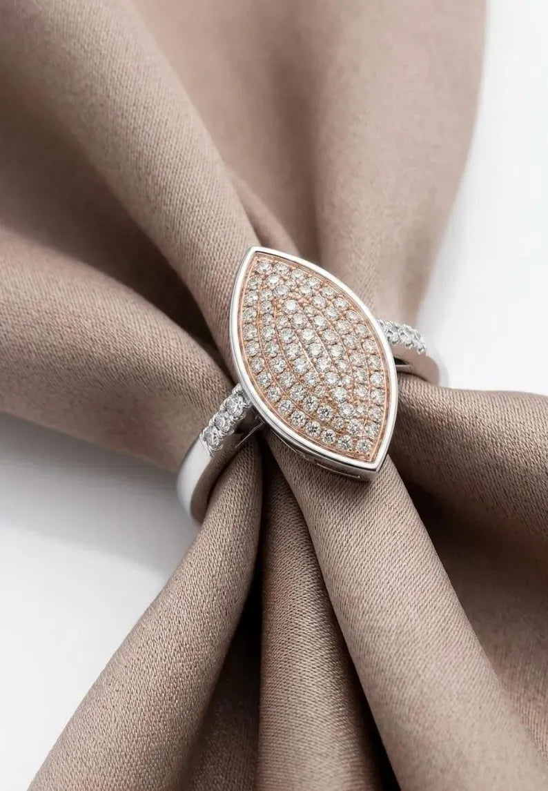Close-up of a 925 sterling silver marquise ring with a rose gold plated pave CZ top, wrapped in taupe fabric