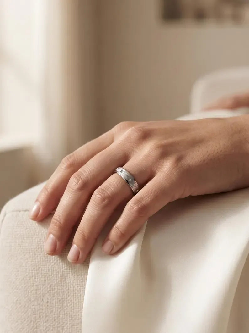Close up of sterling silver brushed ring worn on finger, elegant lifestyle shot