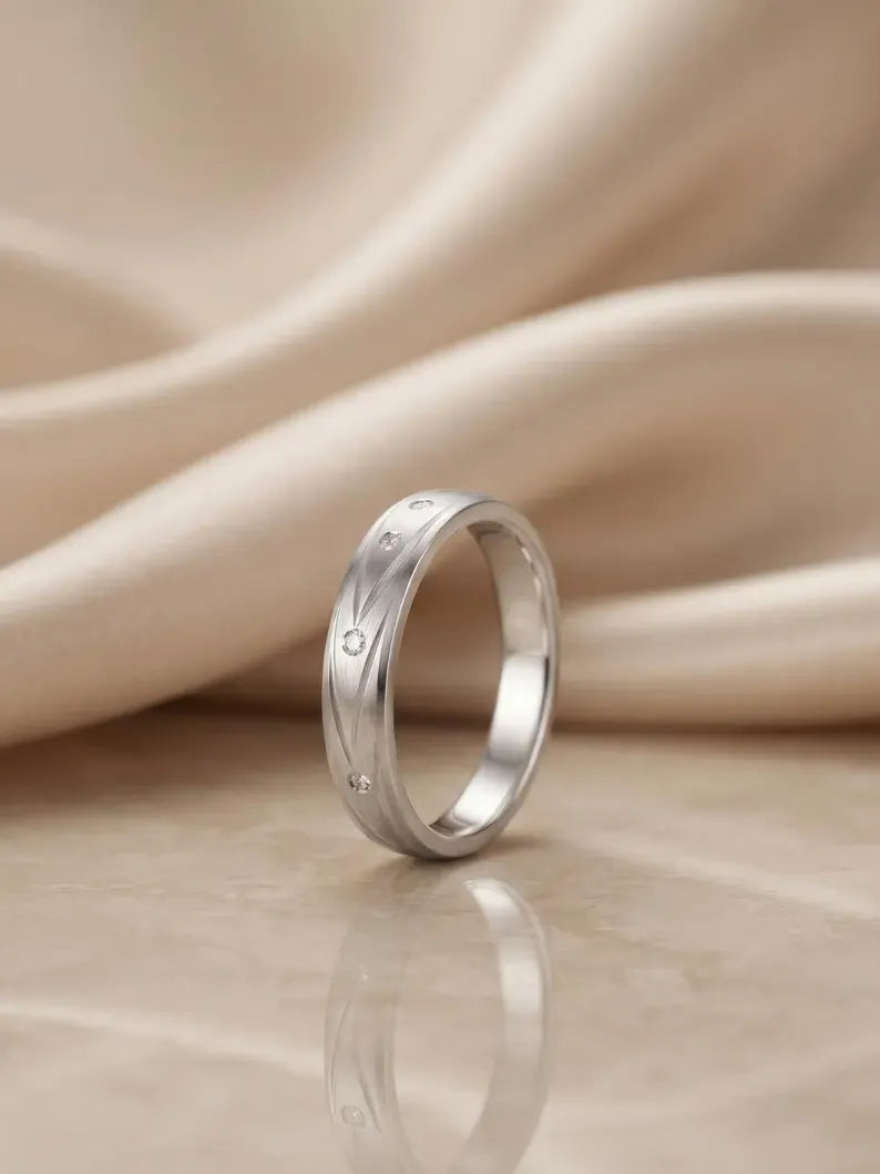 Side angle view of brushed sterling silver men's wedding band with diamond accent stones