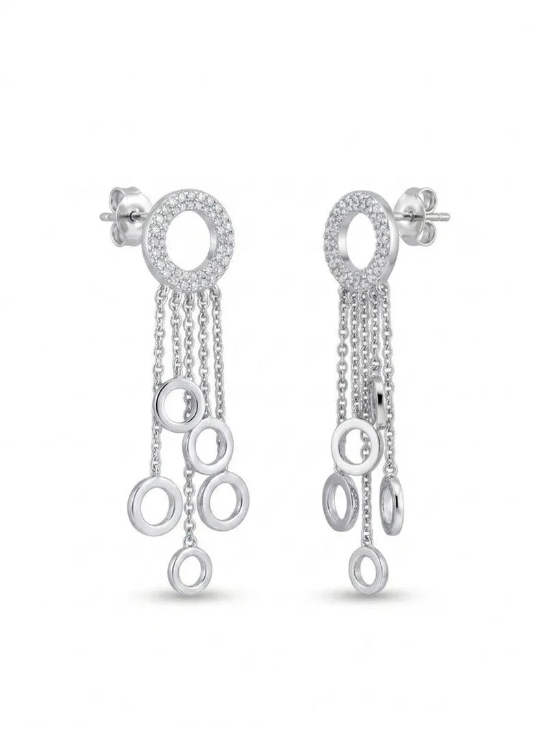 A pair of silver-toned dangle earrings with circular pavé top rings and multiple dangling chain and ring charms, shown on a plain white background.