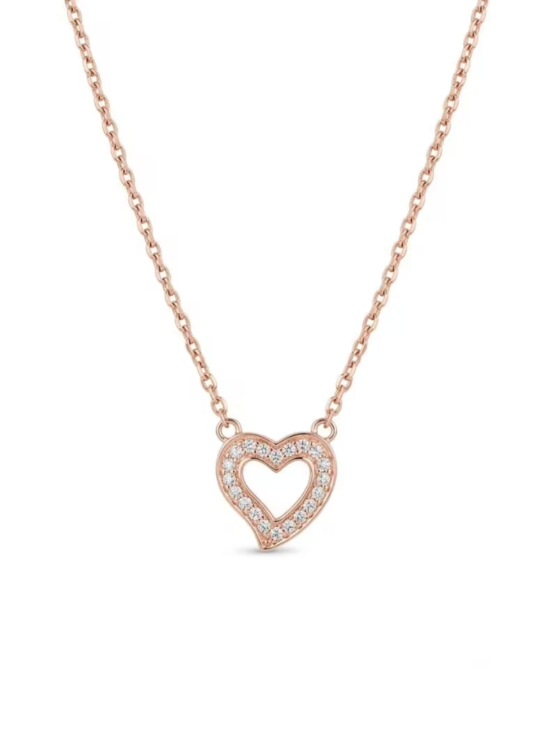 A delicate rose gold chain necklace featuring a heart-shaped pendant with a pavé diamond border, shown against a plain white background.
