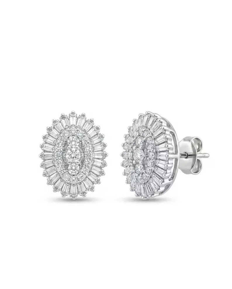 A pair of oval halo stud earrings in silver-toned metal, featuring multiple round and baguette-cut clear stones, shown from both front and side angles on a white background.
