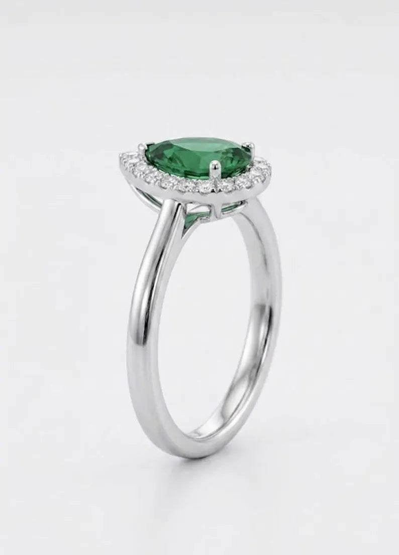 Side angle view of sterling silver pear cut green CZ halo engagement ring