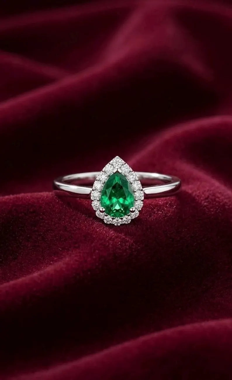 Close up of pear cut emerald green cubic zirconia halo ring in 925 sterling silver