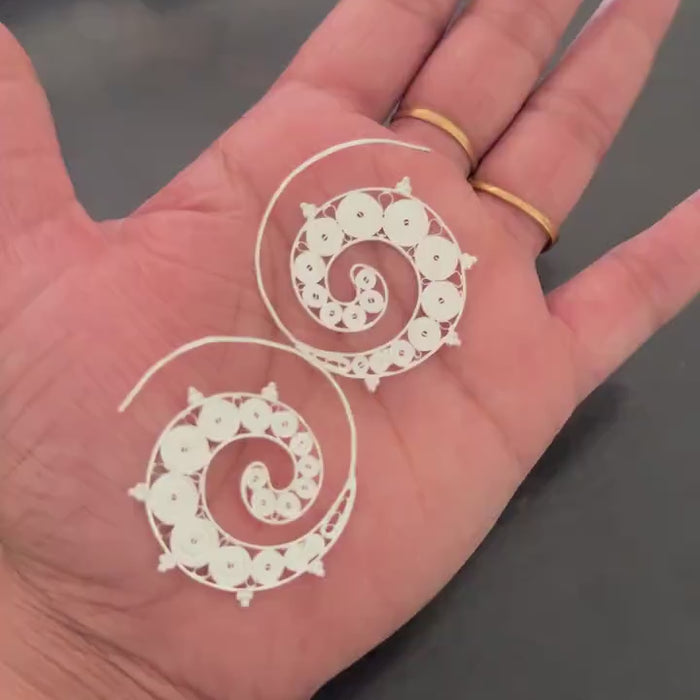 Silver spiral hoop earrings shown from the side