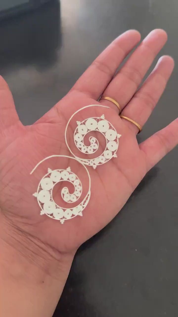 Silver spiral hoop earrings shown from the side