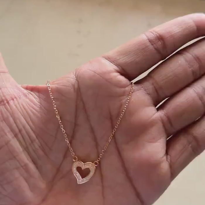 Close-up of zircon detail on rose gold open heart pendant
