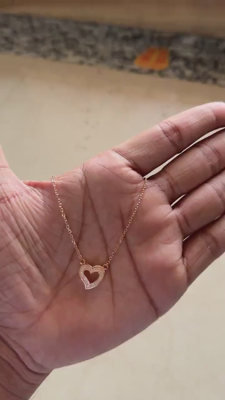 Close-up of zircon detail on rose gold open heart pendant