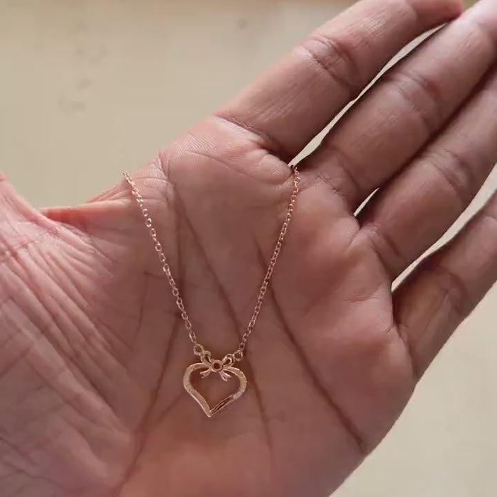 Close-up of zircon detail on rose gold bow heart pendant
