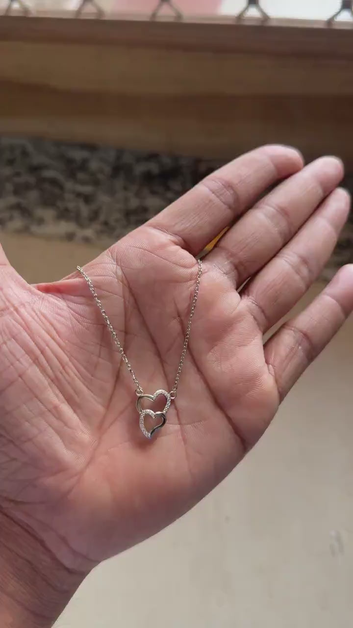 Chain and clasp detail on interlocking heart necklace
