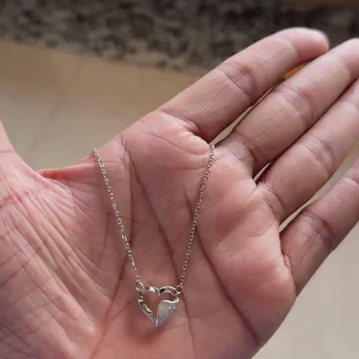Close-up of pavé zircon half on overlapping heart pendant