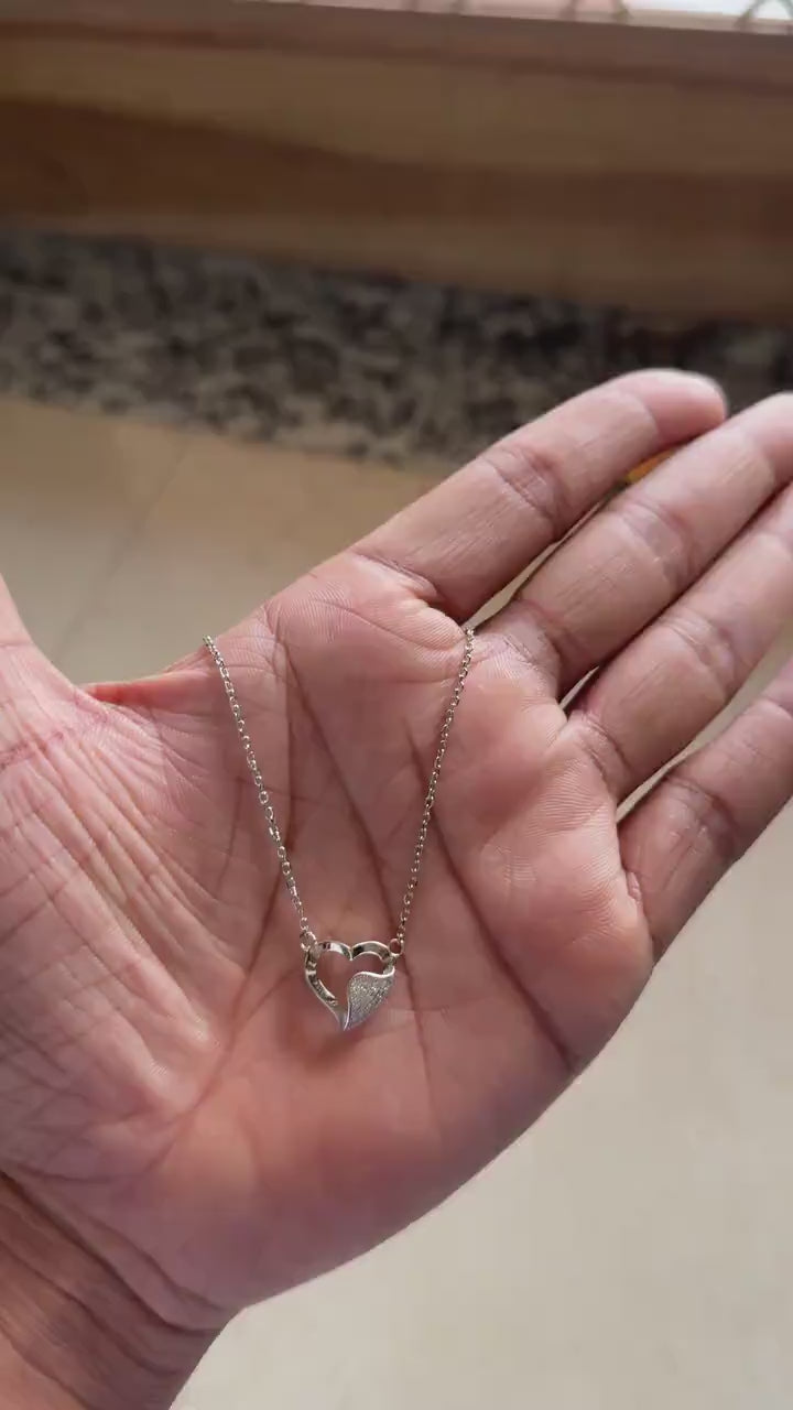 Close-up of pavé zircon half on overlapping heart pendant