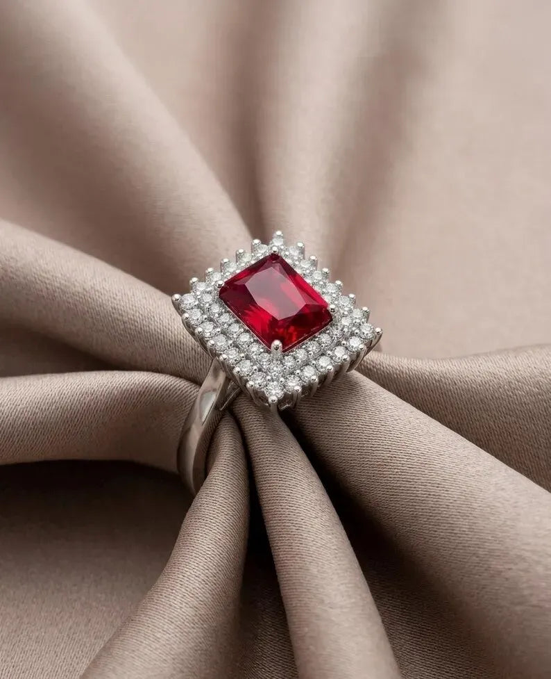 Close up of red emerald cut CZ ring with double halo setting in 925 sterling silver