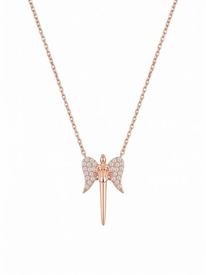 A rose gold angel pendant necklace featuring a winged figure with a dagger pendant, set with small clear stones on the wings, on a delicate rose gold chain against a white background.