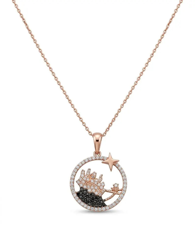A rose gold necklace with a circular pendant featuring a starfish and crown design, embellished with clear and black stones, shown against a plain white background.