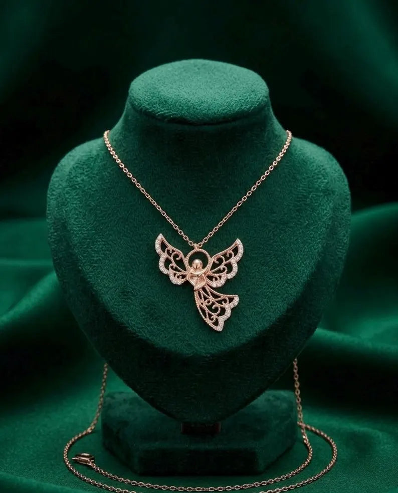 Rose gold butterfly pendant necklace displayed on a dark green velvet jewelry bust against a matching dark green fabric background.
