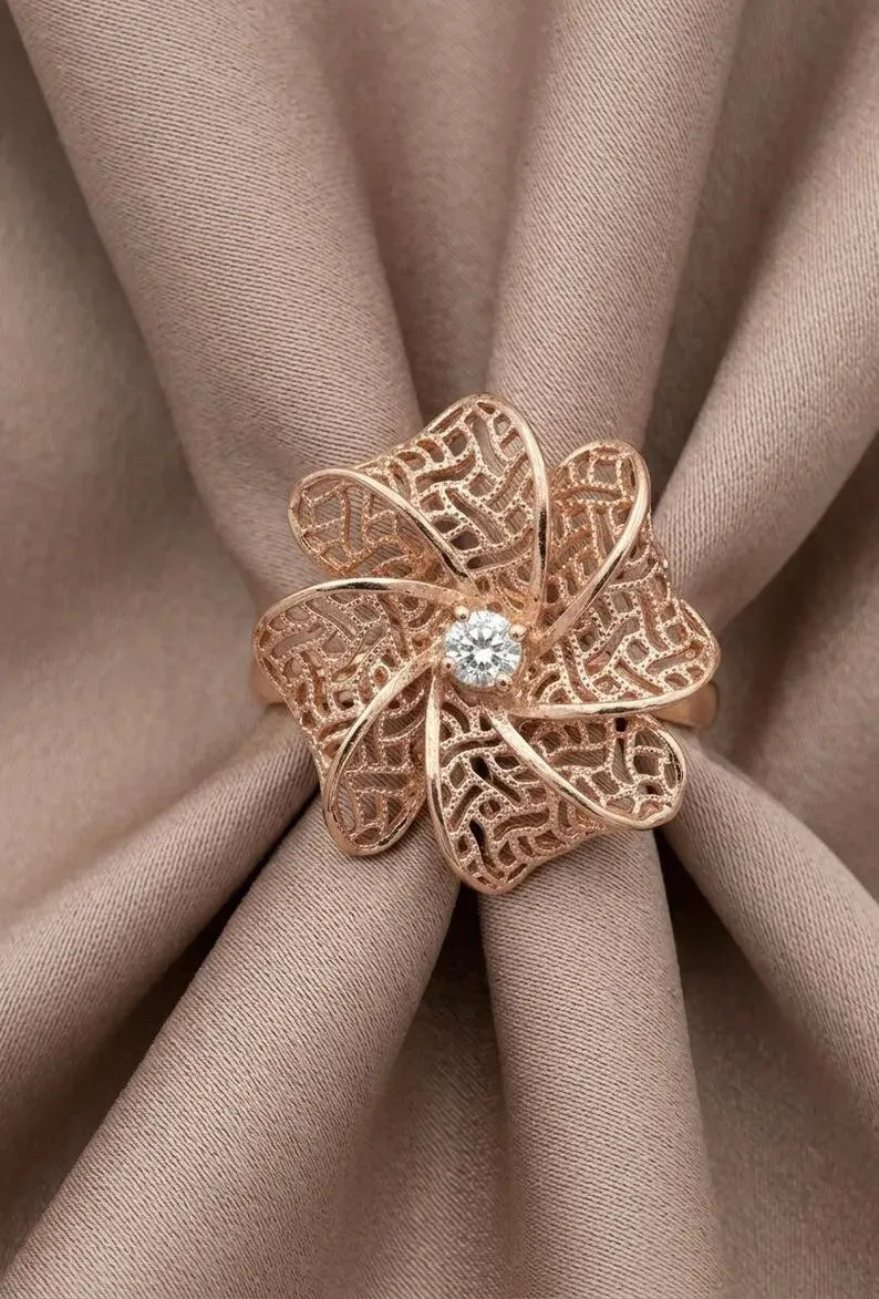 Close up of rose gold sterling silver flower filigree ring with CZ center stone