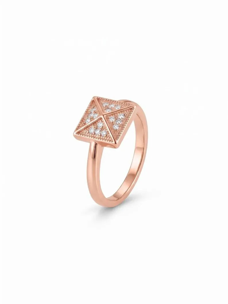 Close up of rose gold geometric cocktail ring on satin fabric background