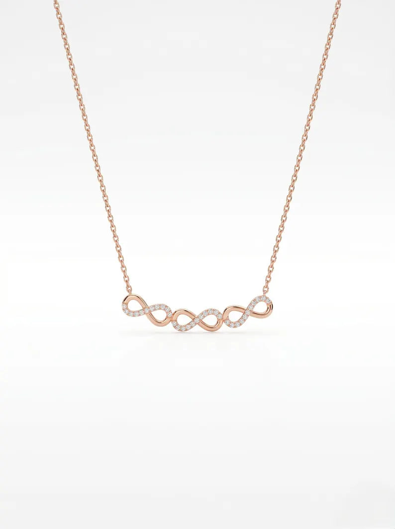 A delicate rose gold necklace with an infinity symbol pendant paved with small clear stones, shown against a clean white background.