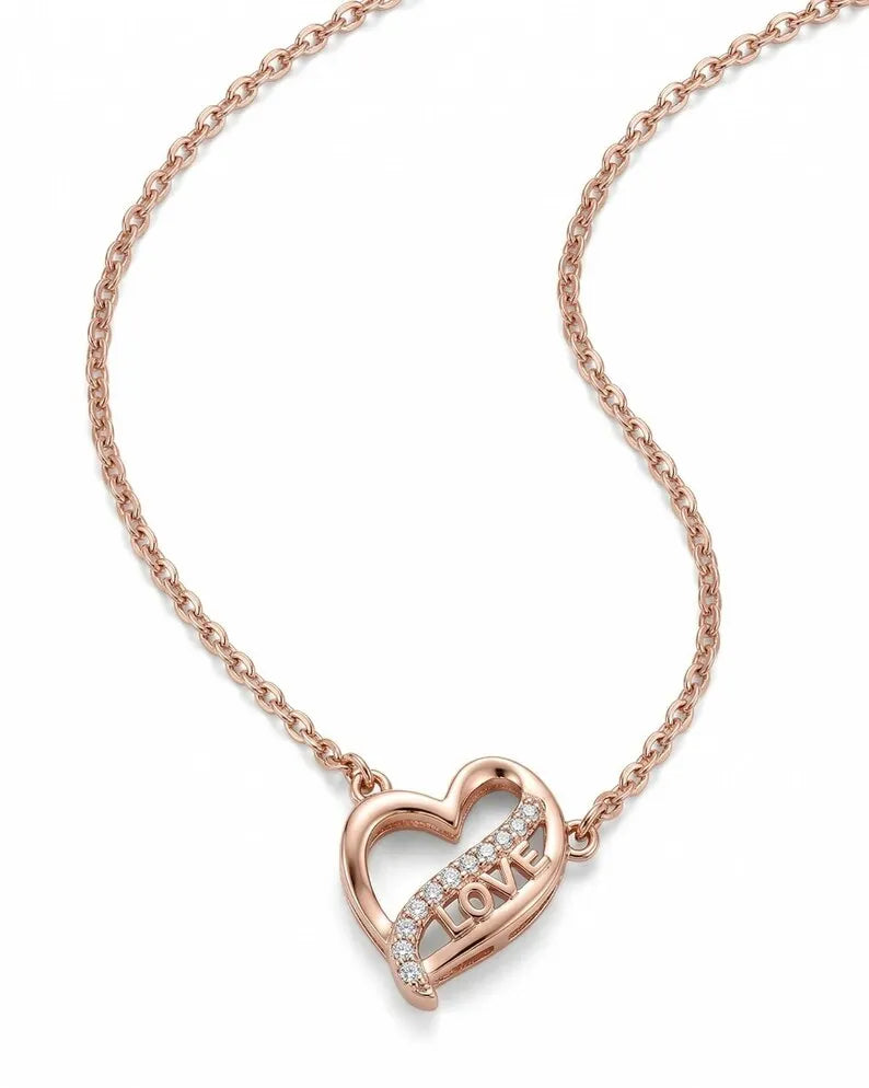 A rose gold necklace with a heart-shaped pendant featuring the word 'LOVE' set in small clear stones, displayed on a clean white background.