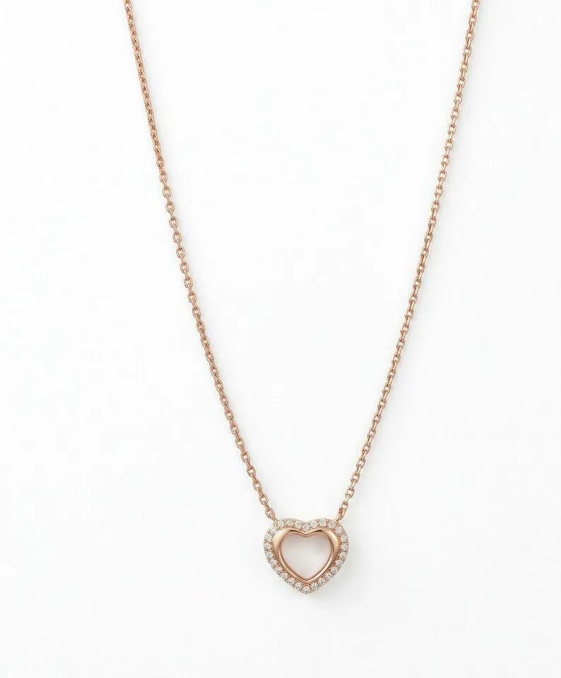 A delicate rose gold chain necklace featuring a small open heart pendant encrusted with tiny clear stones, shown against a plain white background.