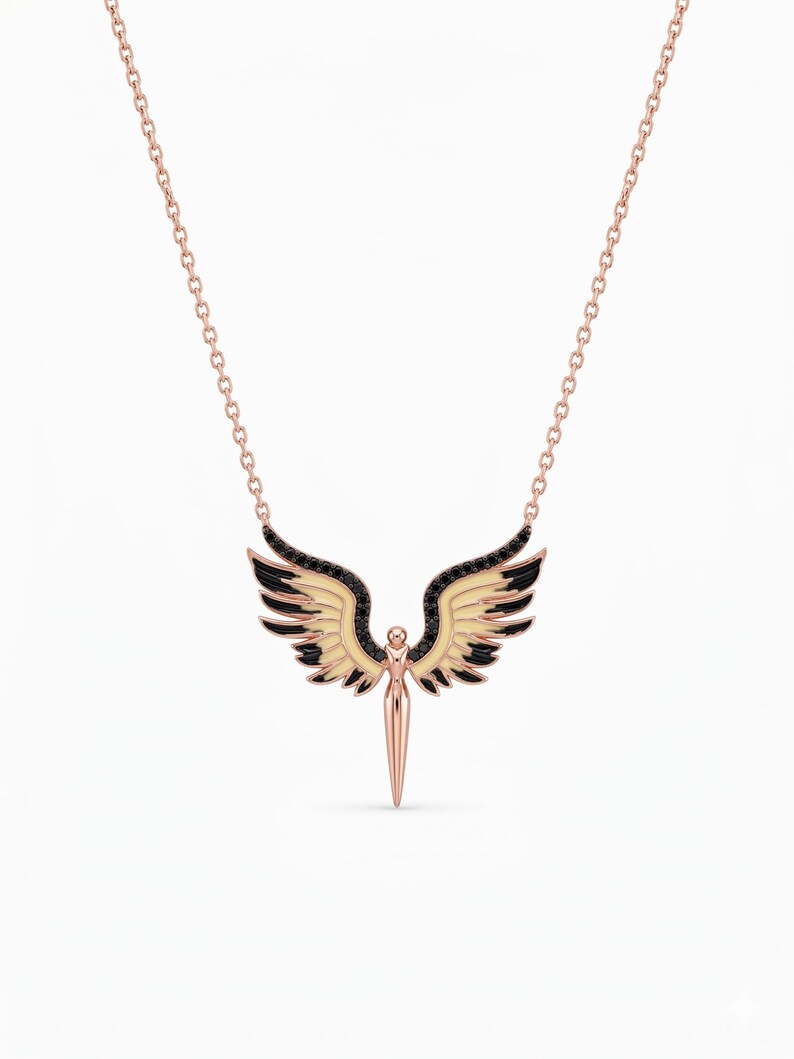 A rose gold necklace featuring a winged dagger pendant with black enamel accents, displayed against a clean white background.