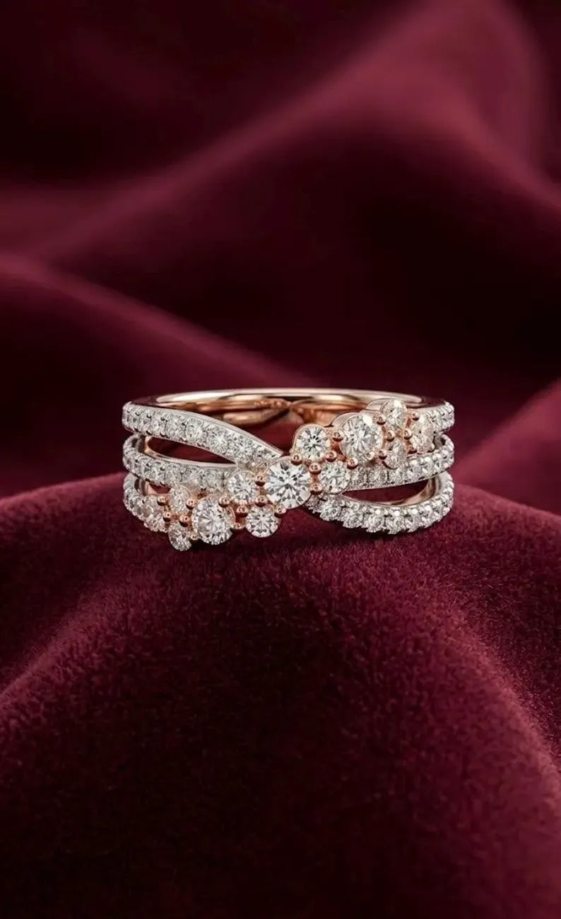 Three-row crossover ring with a rose gold plated stone cluster, resting on deep red velvet