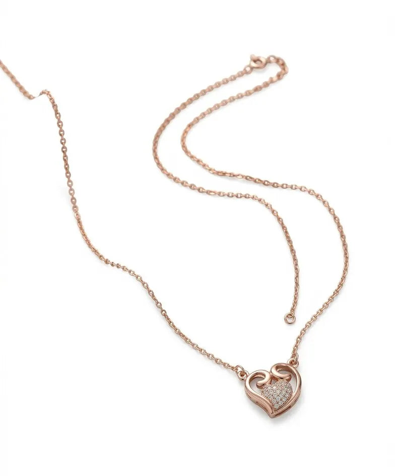A delicate rose gold chain necklace featuring a small interlocking heart pendant, one half of which is set with tiny clear stones, displayed on a clean white background.