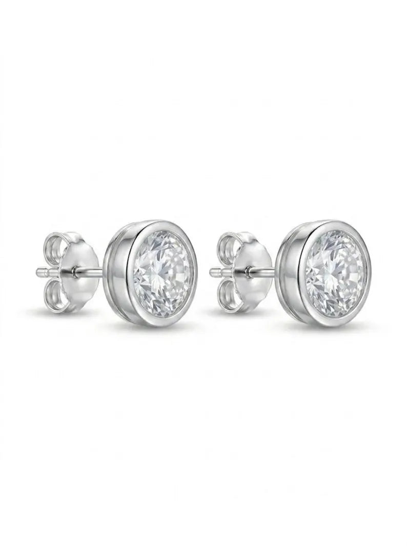A pair of round bezel-set stud earrings in silver-tone metal with clear gemstones, shown on a plain white background.