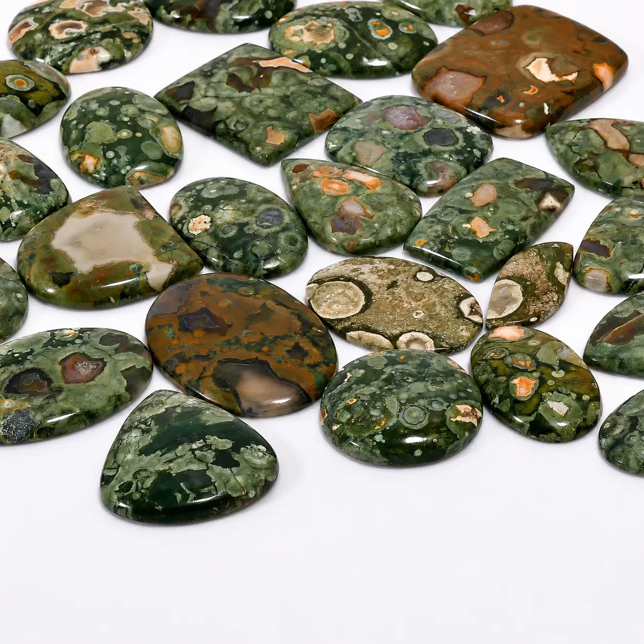 Collection of green and brown marbled stones on a white background