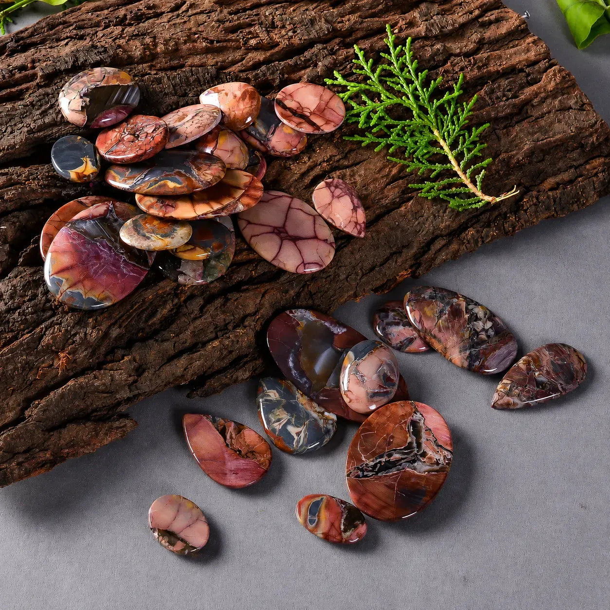 Multicolored stones on a wooden surface with greenery