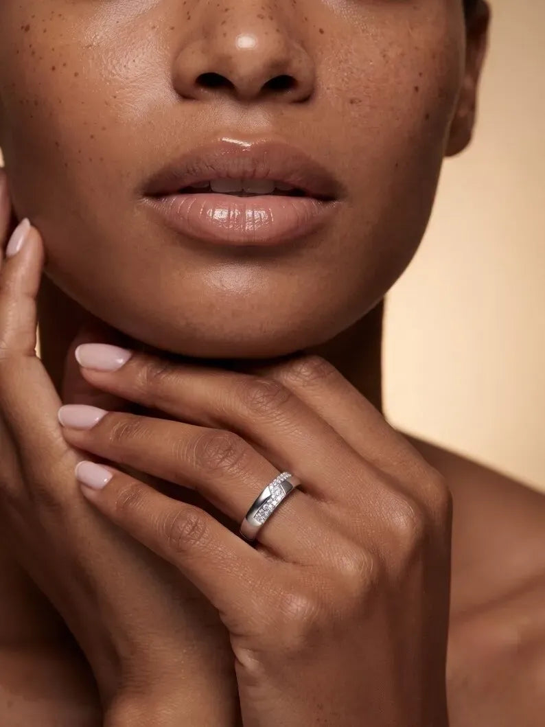 Woman wearing sterling silver minimalist pave band ring near face
